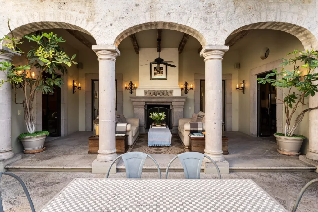 Pórtico con columnas de cantera, chimenea exterior y sala al aire libre en propiedad de Guadiana, San Miguel de Allende