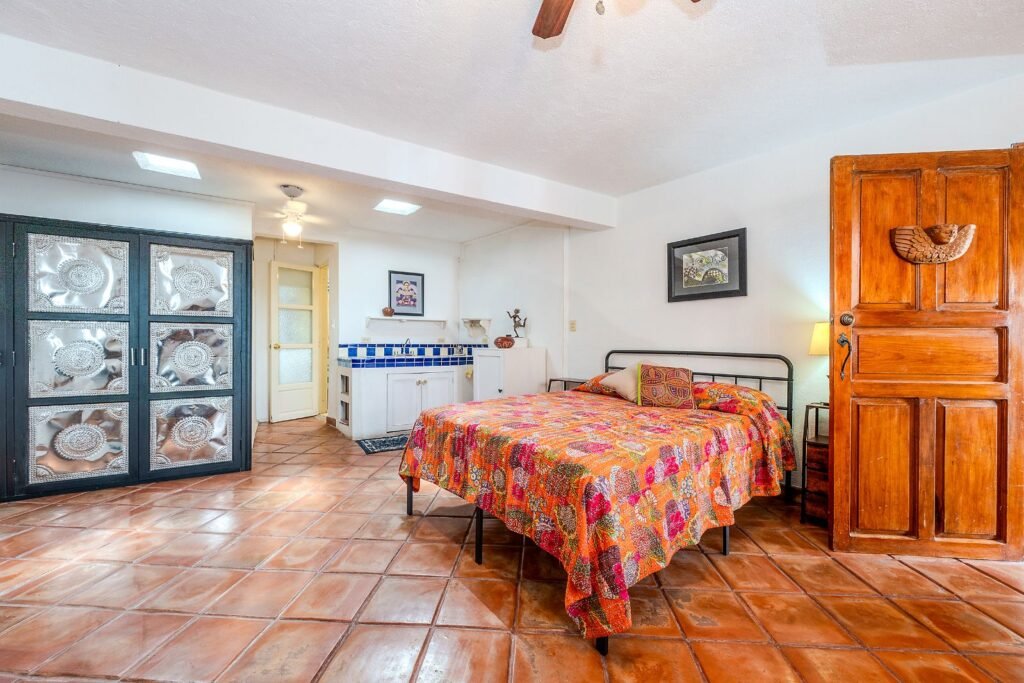 Recámara con piso de terracota y puerta de madera tallada en propiedad del barrio San Antonio, San Miguel de Allende