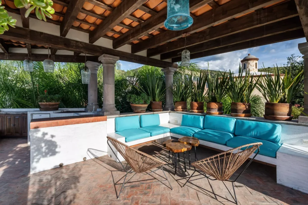 Terraza cubierta con sala lounge en tonos turquesa y vista a cúpula colonial en propiedad de Guadiana, San Miguel de Allende