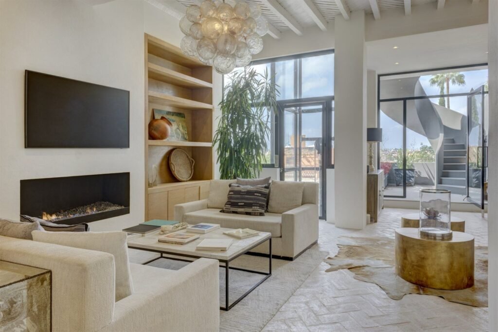 Sala moderna minimalista con chimenea lineal, ventanales y escalera de caracol en propiedad del Centro Histórico, San Miguel de Allende