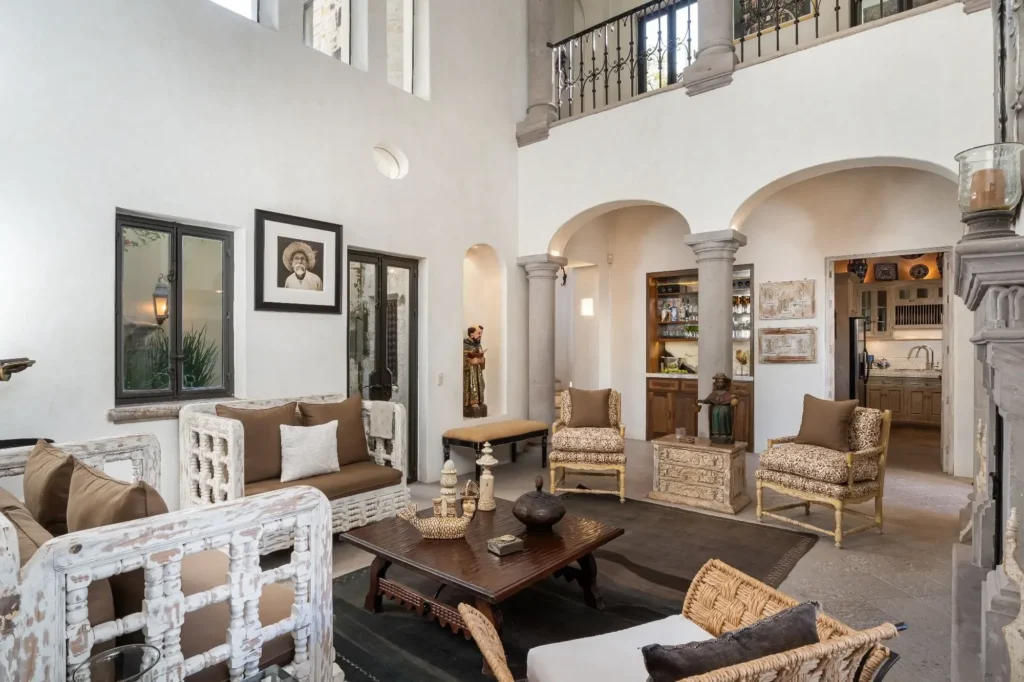 Sala de doble altura con arcos de piedra y decoración rústica mexicana en propiedad de Guadiana, San Miguel de Allende