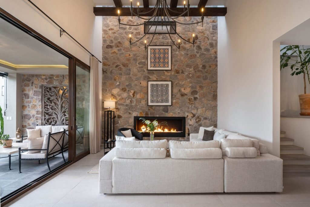 Sala con chimenea moderna, muro de piedra y terraza integrada en propiedad del barrio Balcones, San Miguel de Allende
