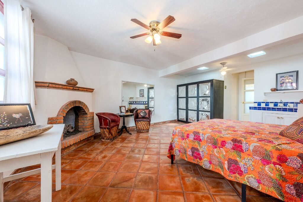 Recámara con chimenea de ladrillo tradicional y piso de terracota en propiedad del barrio San Antonio, San Miguel de Allende